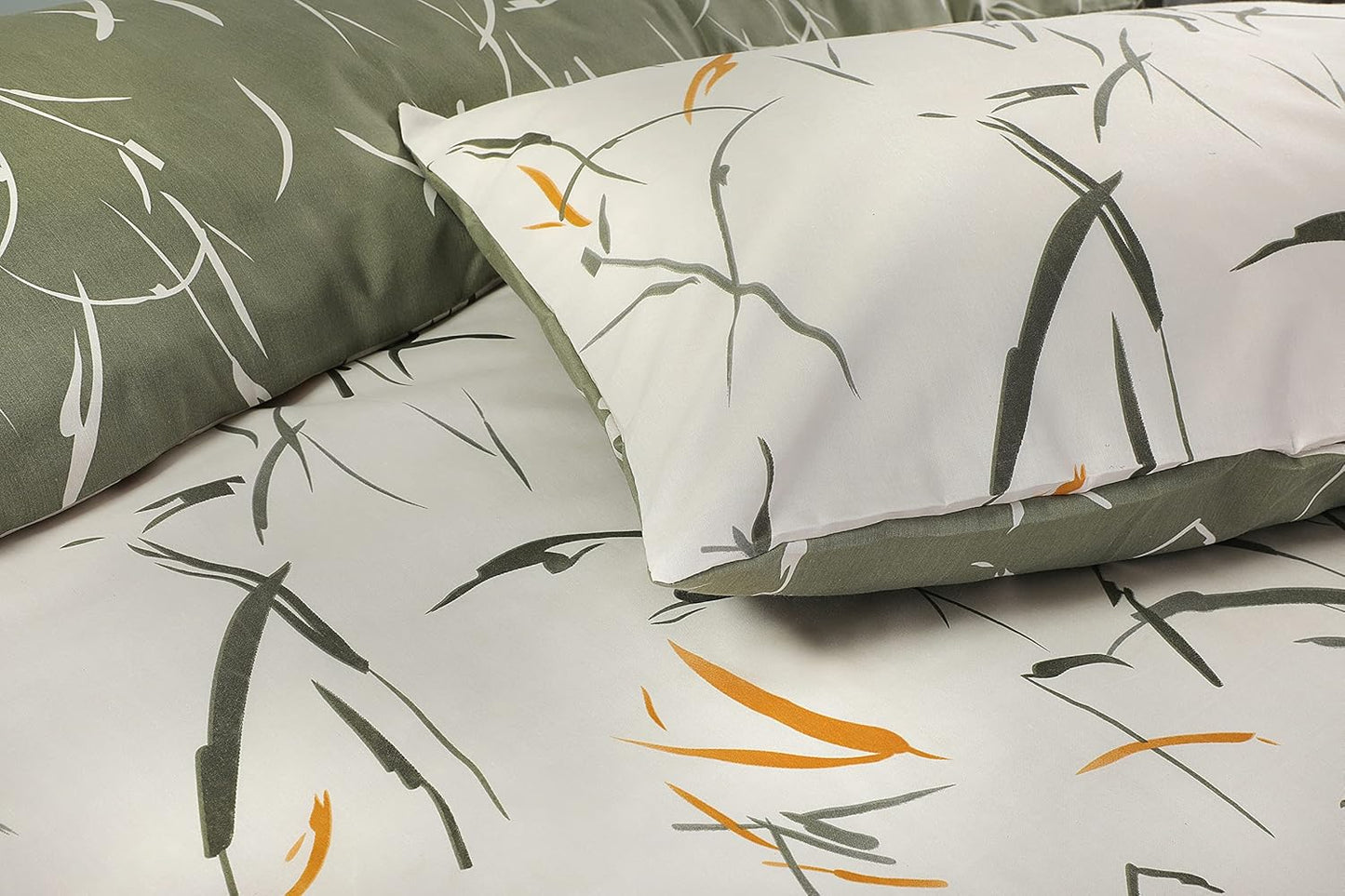 Close-up of Green Leaves bedding showing white pillowcase with sage brushstroke leaves over sage reverse