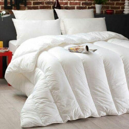 White quilted 13.5 tog duvet with soft-touch cotton cover styled on a bed against an exposed brick wall