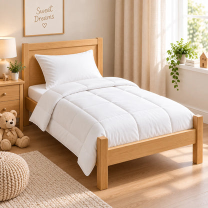 White cot bed duvet and matching pillow set styled on a wooden toddler bed