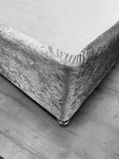 Black and white close-up of elasticated crushed velvet base cover stretched around base corner