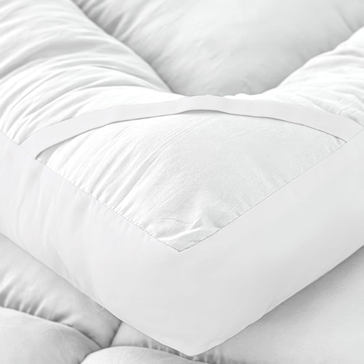 Double bed mattress topper close-up showing soft quilted padding and elastic strap