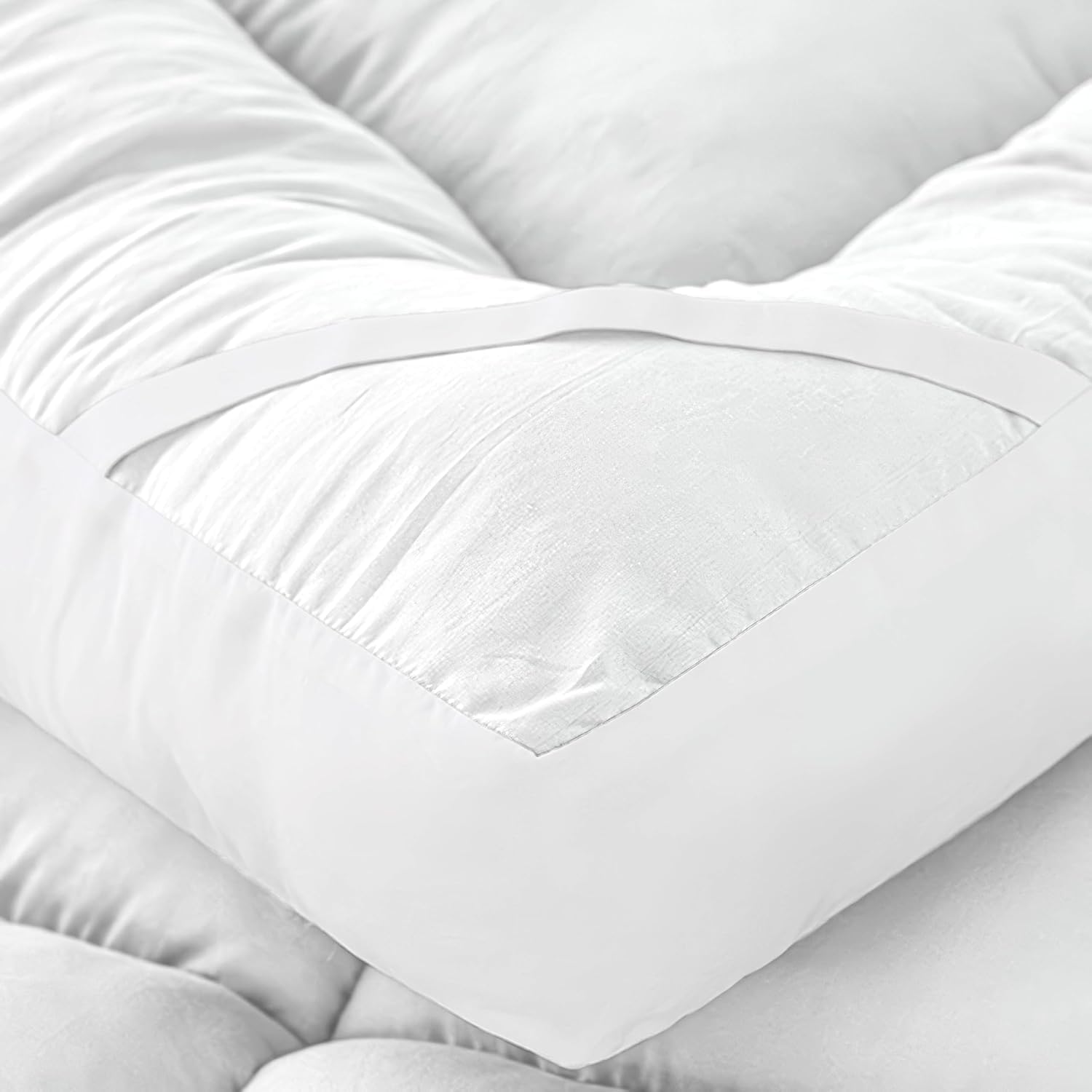 Double bed mattress topper close-up showing soft quilted padding and elastic strap