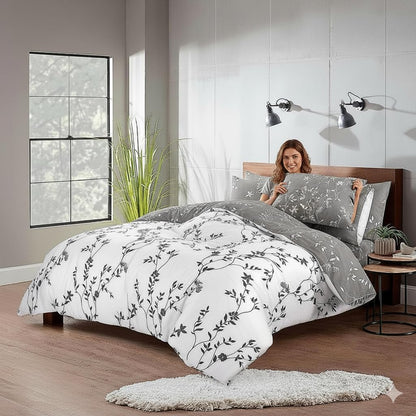 Woman styling grey floral duvet cover set showing reversible white and grey sides