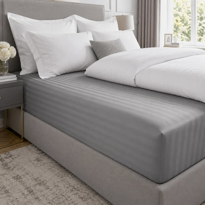 Grey striped 600 thread count 40cm extra deep fitted sheet on a bed