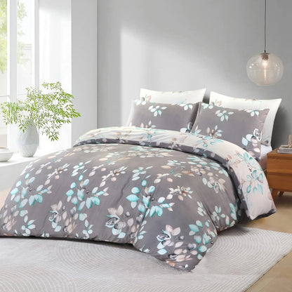 Grey duvet cover set with a teal, blush and cream leaf branch print, shown on a bed with the cream reverse side turned back at the top