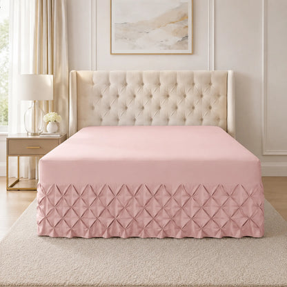 Pink pintuck fitted valance sheet on a bed