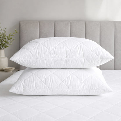 Two luxury quilted hollowfibre pillows on a king size bed in a sage green bedroom — feather-free hotel style pillows by Stoftly