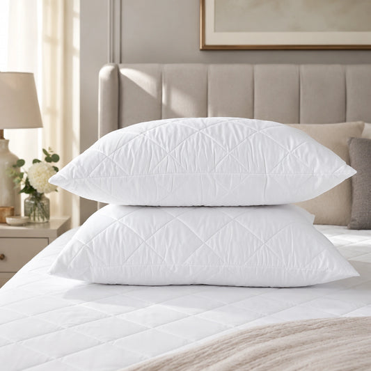 Quilted Pillow 2 Pack with diamond-stitched covers stacked on a bed with quilted mattress protector — Stoftly hotel quality pillows