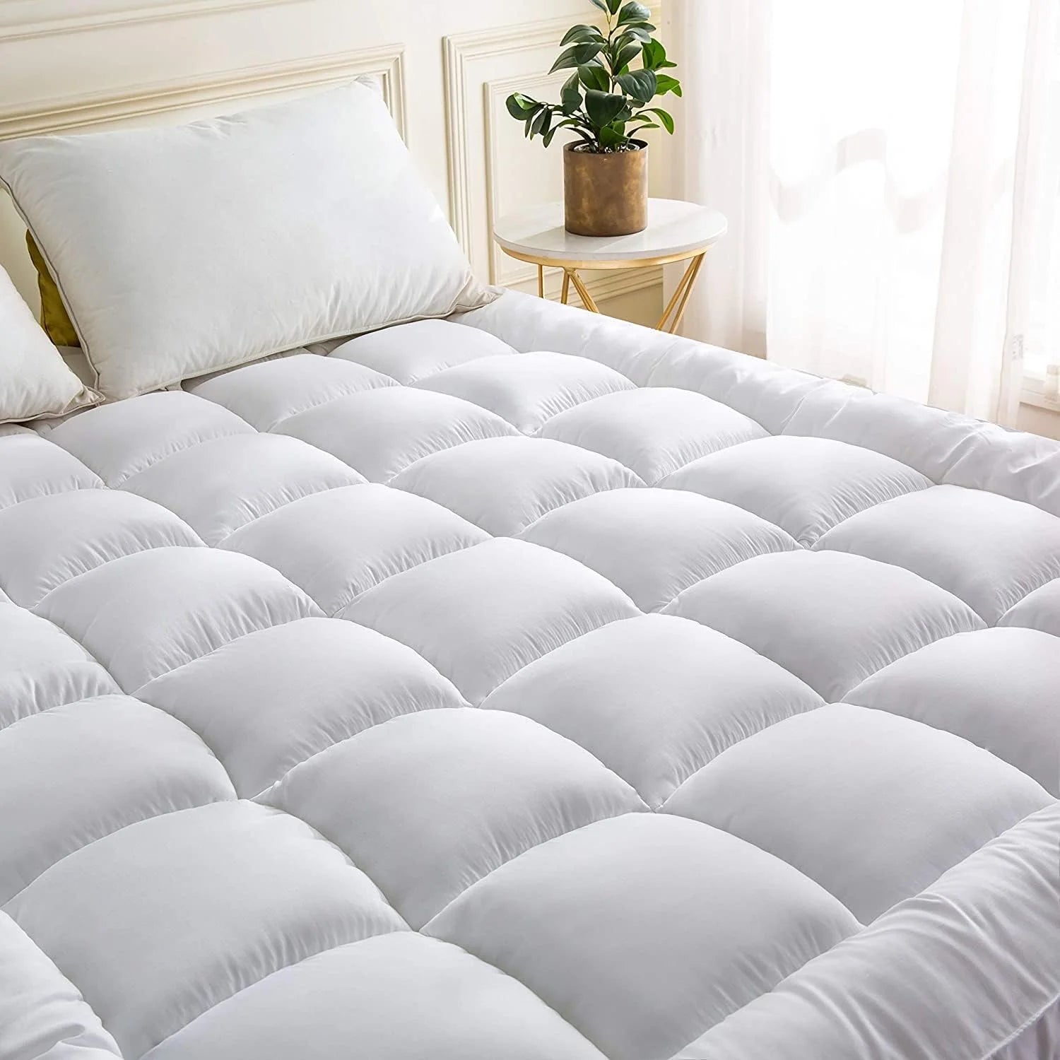 Super king mattress topper with soft quilted comfort layer on bed