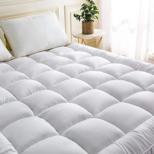 Super king mattress topper with soft quilted comfort layer on bed