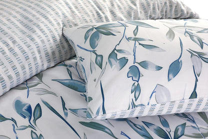 Close-up of blue and grey leaf print pillowcase with textured stripe fabric detail