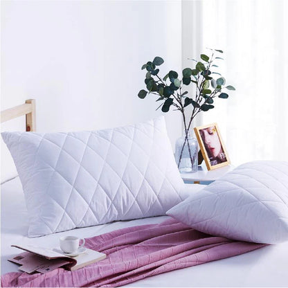 White quilted pillow protectors shown in a clean bedroom setting